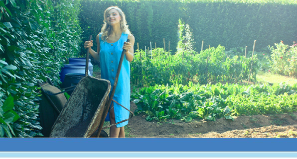 woman in front of garden with wheel barrel
