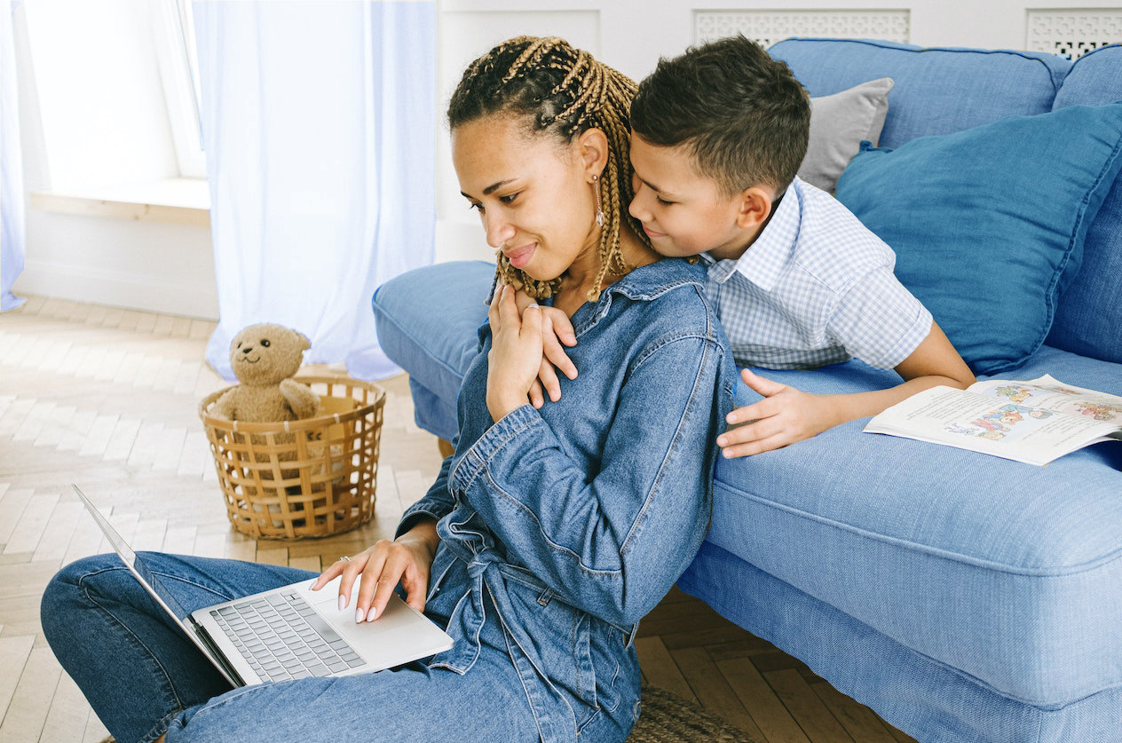 Young Boy Hugging Mother with Laptop