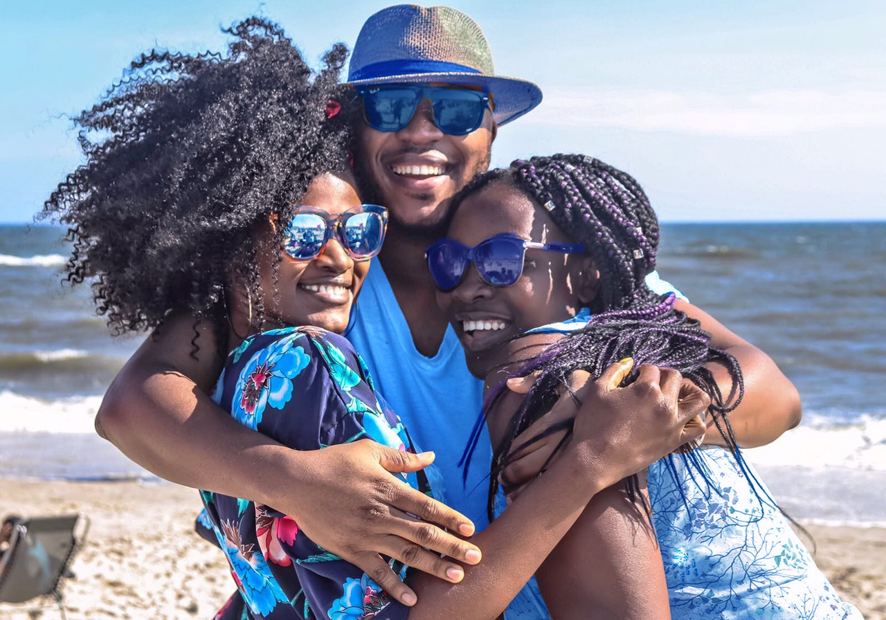 Man and Two Woman Hugging on Beach