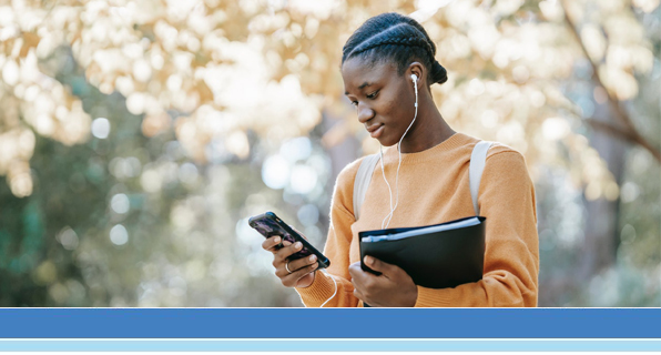 college kid holding books looking at phone