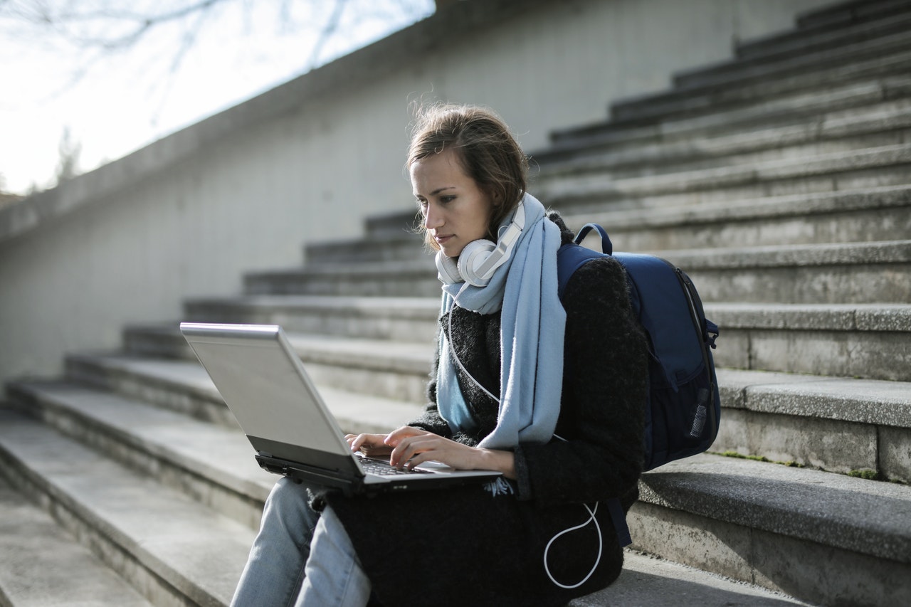 Women Sitting with Backpack and Laptop
