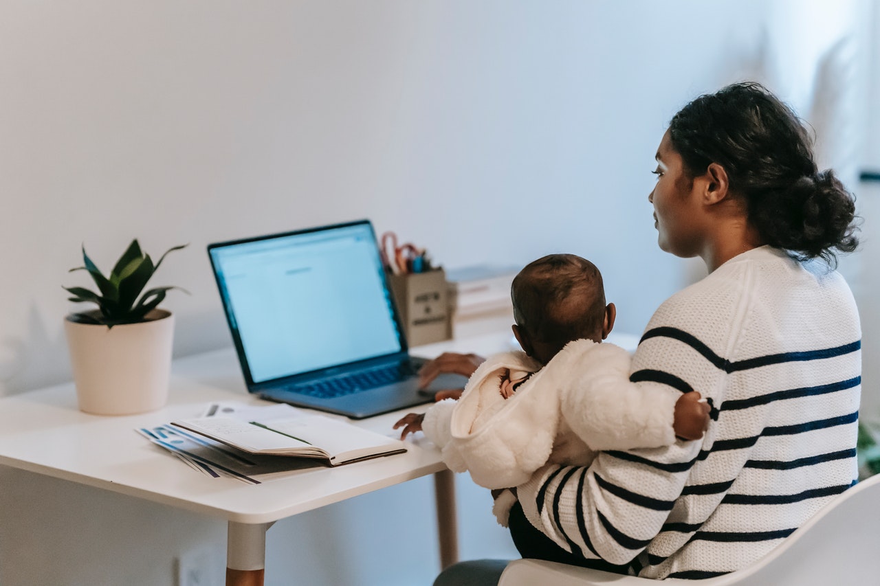 Woman Working at Computer Holding Baby