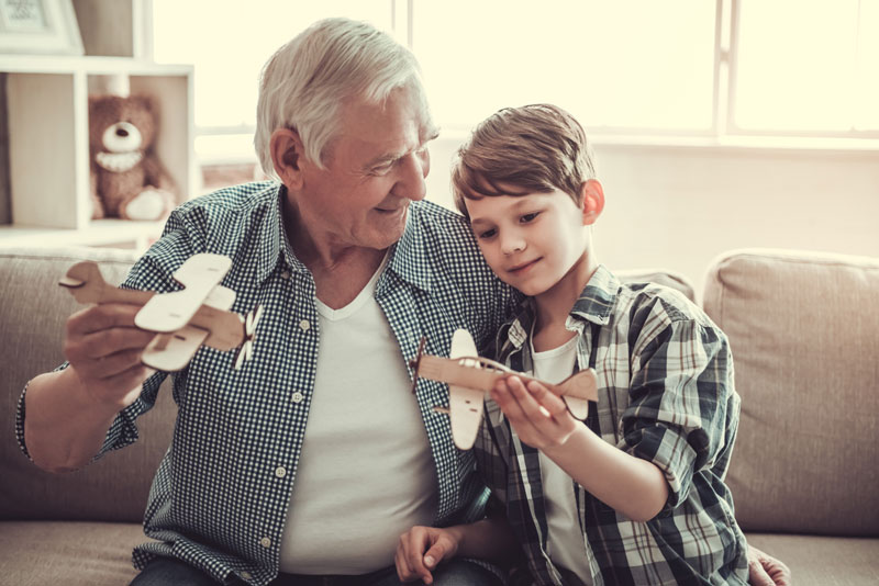 grandfather and grandchild playing with an airplane