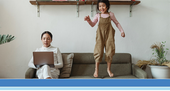 mom on laptop, daughter jumping