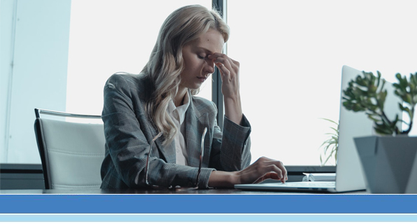 woman at desk looking stressed